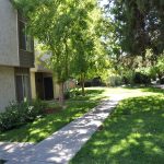 AlvaradoParkside exterior area with walking paths and large trees