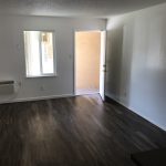 College Street Apartments living room with wall AC and open front door