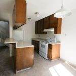 Viking Apartment kitchen with dark wooden kitchen cabinets and white counters, tile floors